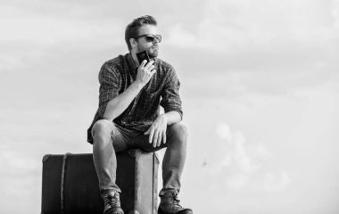 Ulaşım tesisleri. Bagaj konsepti. Yakışıklı gezgin. Klasik valizli bir adam. Taksi çağırıyorum. Seyahat acentesi. Bagajla seyahat et. Gezgin blogcu. İnsan yolculuktan önce bavula oturur.