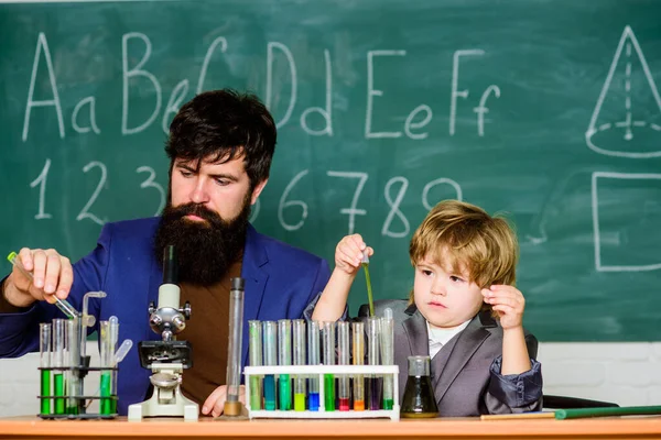 Special and unique. Genius kid. Joys and challenges raising gifted child. Teacher bearded scientist man child test tubes. Chemical experiment. Genius child private lesson. Knowledge day. Genius minds