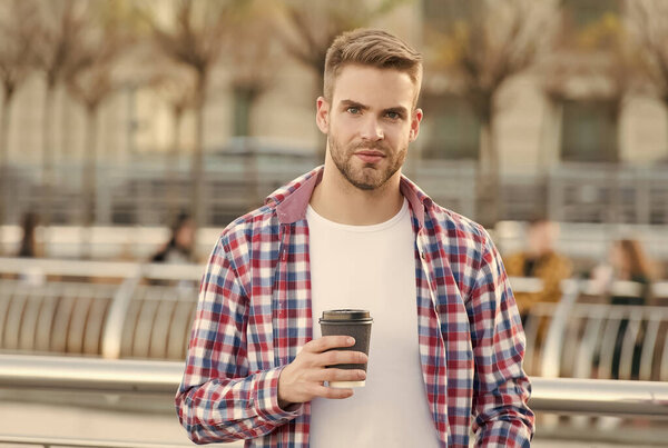 casual dressed male drinking morning coffee from cup outdoor, modern life
