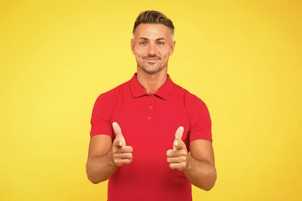 Pazarlama ve satış sarı arka planı için kırmızı tişörtlü mutlu adam işaret parmakları — Stok fotoğraf