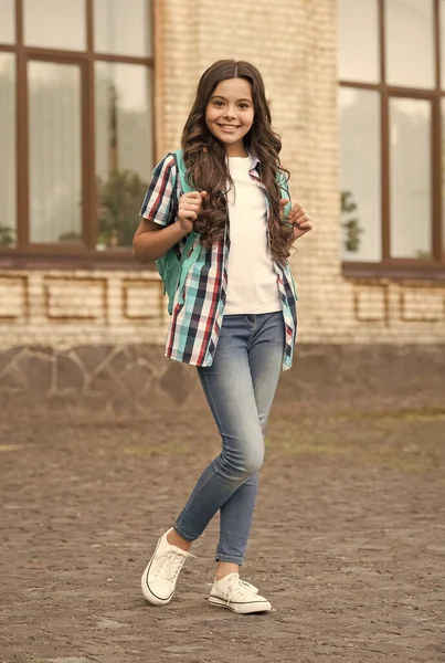 Ragazza felice con lunghi capelli ondulati in stile casual trasportare borsa da viaggio urbano all'aperto, vacanza — Foto Stock