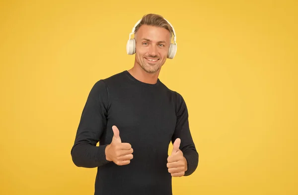 Only the best. music and digital technology. ebook and elearning. unshaven guy in headset listening song. musical app playlist. quality wireless device. happy man wearing earphones show thumb up — Stock Photo, Image