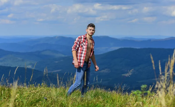 Poder da natureza. Camisa desabotoada homem stand top montanha paisagem fundo. Torso muscular forte caminhante. atleta muscular cara relaxar montanhas. Conceito de caminhada. Passeio turístico muscular montanha colina — Fotografia de Stock