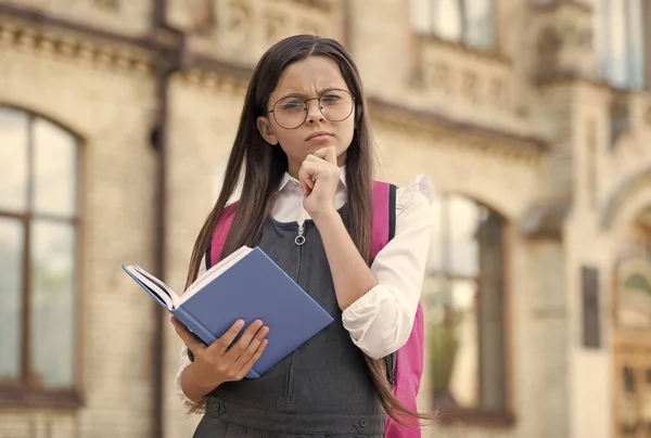 Stellen Sie sich Ihre Träume vor. Kleines Kind hält Buch mit nachdenklichem Blick. Fantasievolles Denken. Schulzeit. Kindheitsfantasien. Lesestunde. Fantasie und Kreativität. Alphabetisierungsbildung — Stockfoto