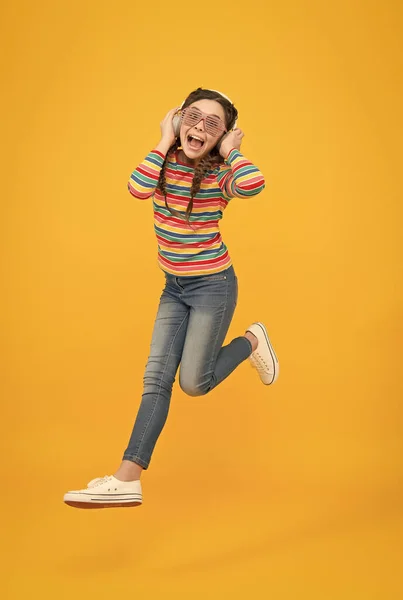 Juste danser. enfant sauter dans des lunettes de fête. bonne enfance. Je m'amuse. sa chanson préférée. adolescent fille écouter de la musique dans les écouteurs. Joli gosse aux cheveux tressés. glamour et drôle. vie moderne — Photo