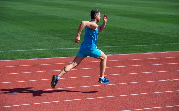 Atlético muscular homem corredor correndo no estádio, energia — Fotografia de Stock