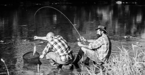 Black market caviar. Poachers fishing. Trap for fish. Men sit at riverside with fishing equipment. Illegal hunting caviar. Extracts eggs from sturgeon caught river. Poaching crime and fishing license — Stock Photo, Image