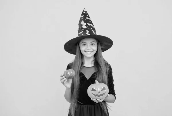 Halloween kind in heks hoed houden pompoen jack o lantaarn voor hekserij, halloween pompoen — Stockfoto