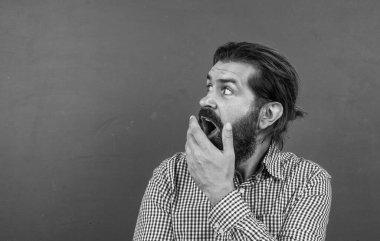 Kafkas hippiler yeşil arka planda şaşkınlık hissederler. kopyalama alanı. Tahtanın arka planında olgun bir öğretmene sürpriz oldu. Vahşi sakallı adam sıradan bir kareli gömlek giyer. insan duygularını ifade etmek