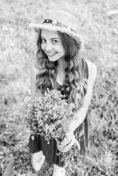 Happy girl curly hair harvesting flowering herbs in field, natural remedies — Stock Photo, Image