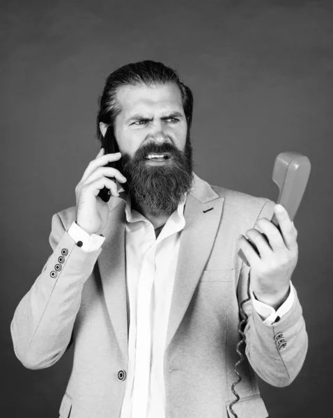 bearded hipster use retro telephone. communication concept. brutal handsome man with moustache speak on smartphone. call and conversation. modern and vintage technology. Get enlightened