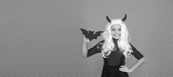 Enfant heureux sur Halloween porter costume de carnaval drôle et cornes intérieur tenant petite chauve-souris, tour ou régal. espace de copie — Photo