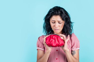 Mutsuz, esmer, güzel bir kadın. Kırmızı cüzdan tutuyor, tasarruf ediyor.