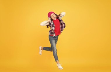 Bırak müzik seni götürsün. Enerjik kız müziğe geçti. Küçük çocuk sarı arka planda şarkı söylemeyi seviyor. Kulaklık teknolojisi. Modern hayat. Mutlu danslar. Anı oyna