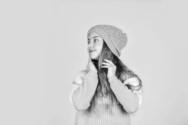 Bellezza e moda del capretto. riscaldarsi durante la stagione invernale. previsioni del tempo freddo. felice bambino indossare cappello e maglione preferito. felicità infantile. teen girl sfondo giallo. copia spazio — Foto Stock