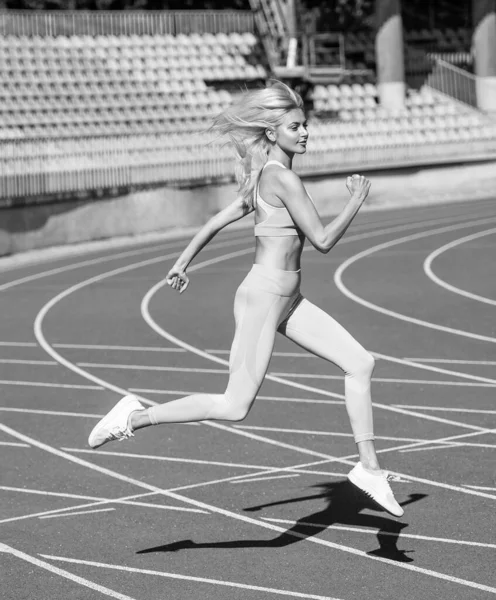 Fit lady w stroju fitness działa na stadionie tor wyścigowy podczas treningu sportowego, wytrzymałość — Zdjęcie stockowe