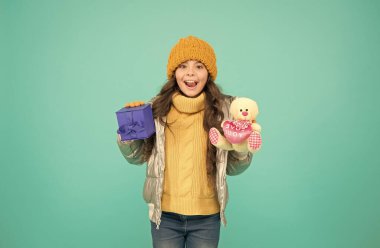 İkisini de istiyorum. Ekstra bonusla online alışveriş. Küçük kız Noel hediyesine şaşırdı. Sevgiyle hediye. Mutlu noeller. Mutlu yıllar. Kış tatili için hediye. Sıcak kış kıyafetleri içinde şık bir çocuk.