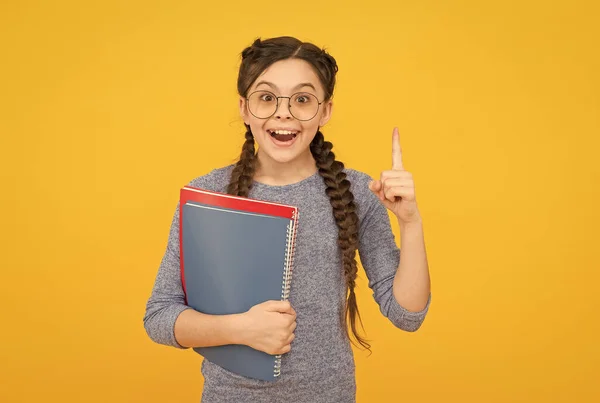 Toma el libro de la biblioteca. Cursos para niños dotados. La escuela es genial. Educación privada. Linda colegiala sonriente. Una colegiala. Alumno con trenzas yendo a la escuela. Colegiala vida cotidiana — Foto de Stock