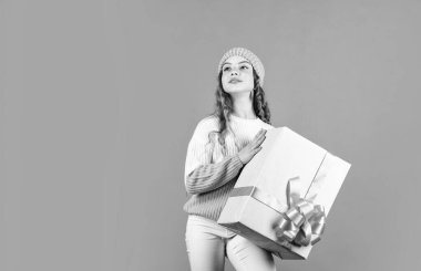 İyi tatiller. Neşeli küçük kız örgü şapka ve kazak örüyor. Doğum günü sürprizi. Çocuk hediye kutusunu tut. Alışveriş merkezi konsepti. Doğum günü kutlaması fikri. Keyfin yerinde. Doğum günü geleneği