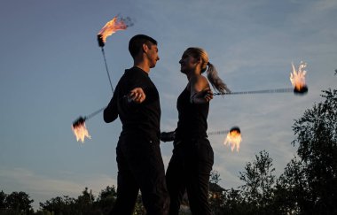Ateş ve alev. Seksi çift poi dansı yapıyor mavi gökyüzü. Flamimg poi sallanıyor. Yangın gösterisi. Alevli sanat. Gece partisi. Yaz festivali. Sıcak ve ateşli