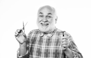 Son dokunuş. Beyaz sakallı, olgun bir adam. Makas kes ve saç fırçala. Berber dükkanı konsepti. Traş aksesuarları. Tıraşsız yaşlı adamın bıyığı ve sakalı var. Tıraş bıçağı alet çantası