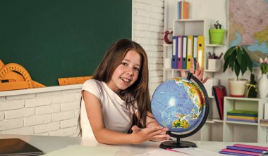 Coğrafya. Okula dönüyorum. Modern hayatta resmi eğitim. Evde eğitim kavramı. Çocukluk gelişimi. İnceleme yoluyla bilgi edinmek. Sınıfta tahtası olan bir çocuk. Çocuk küreye bak.