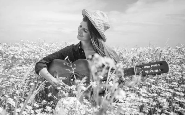 Lycklig kvinna samla blommor i sommar kamomill fält spela akustisk gitarr, country musik — Stockfoto