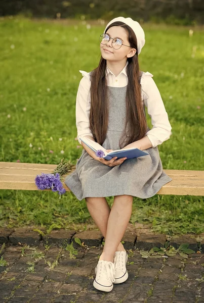 Elegante colegiala niña leyendo libro en el parque, aprender concepto de gramática —  Fotos de Stock