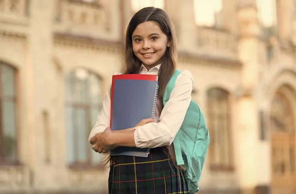 Κοριτσάκι σχολική στολή μαθητή και σακίδιο κρατήσει βιβλία, επίσημη έννοια της εκπαίδευσης — Φωτογραφία Αρχείου