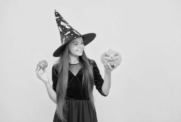 Menina adolescente feliz usar chapéu de bruxa segurando abóbora para criar jack o lanterna no dia das bruxas, halloween truque ou tratar — Fotografia de Stock