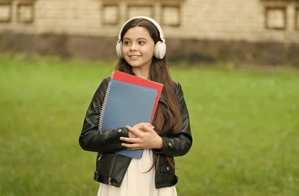 Music is cool. Cool child listen to music outdoors. Happy girl use headphones for listening. Private language school. Cool learning technology tools. Modern life. Cool skills to learn