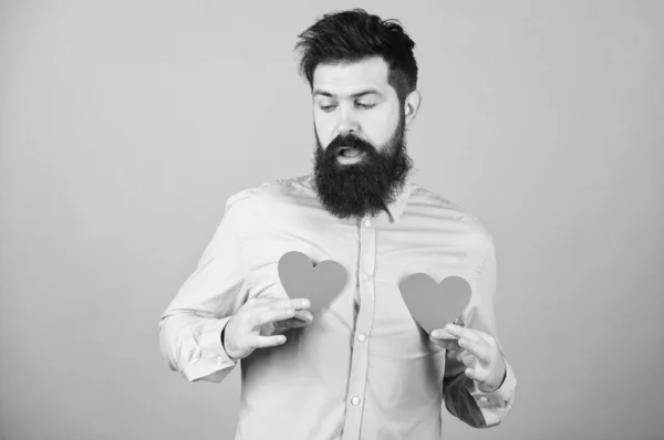 A day when love finds its way. Bearded man holding red hearts. Hipster with small hearts. Sexy valentine man with heart shaped decorations. Happy valentines day. The holiday of love and romance — Stock Photo, Image