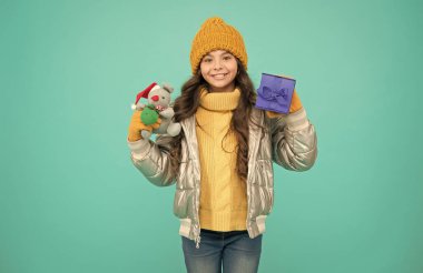 İnternetten satın alma bonusu. Mutlu küçük kız hediyesi. Noel sezonunda alışveriş. Mutlu noeller. Mutlu yıllar. İyi bir hediye için minnettar hissediyorum. Moda ceketli modacı çocuk. Sıcak kış giysileri