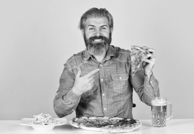 Daha iyi olamazdı. Barda akşam yemeği. Aç adam pizza yiyecek ve bira içecek. Sonunda pizza zamanı. Pizzacı. Neşeli sakallı hippi adam pizza yiyor. Pizza partisi konsepti. Bira ve yemek.