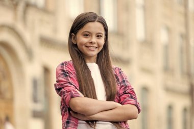 Kızların güvenini arttırıyor. Kendine güvenen çocuk kollarını açık havada çapraz tut. Moda kızının kendine güveni tam. Sıradan bir tarz. Yaz trendi. Modayı takip eden çocuklar giyer. Çocuk kıyafetleri. Her gün harika olacak.