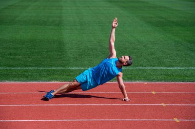 Atletik kaslı adam antrenmandan önce ısınıyor, yoga