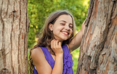 Tam dişler harikadır. Mutlu çocuk gülüşü yazın açık havada ağaçta. Diş sağlığı. Ağız temizliği. Sağlıklı ağız ve diş etleri. Pediatrik dişçilik. Daha iyi dişler, daha sağlıklı