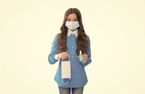 女童带着防护面罩和清洁剂，清洁用白色隔板隔离的双手，以防止弧菌病毒大流行，并采取防腐措施 — 图库照片