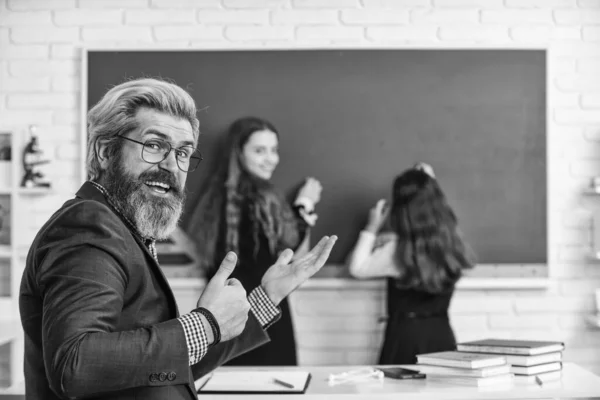 Divulgare e sviluppare la creatività. concentrazione selettiva. Insegnante che lavora con i bambini. bambine bambini a scuola. Torniamo a scuola. Insegnanti e alunni che lavorano insieme alla scrivania della scuola elementare — Foto Stock