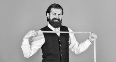 Fikirleri kıyafete dönüştürmek. Erkek kıyafetleri terziliği yapan adam. Vahşi adam moda tasarımcısı. Adam erkekler için kostüm tasarlıyor. Sartor çalışmaya hazır. Resmi ve ofis tarzı. Mezuralı terzi.