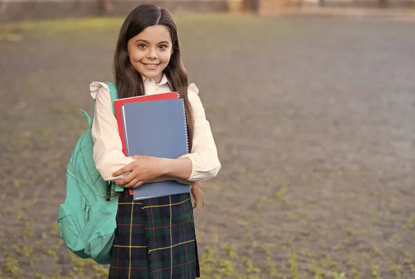 Little girl formalny styl mundur i plecak trzymać książki, koncepcja harmonogramu szkoły — Zdjęcie stockowe