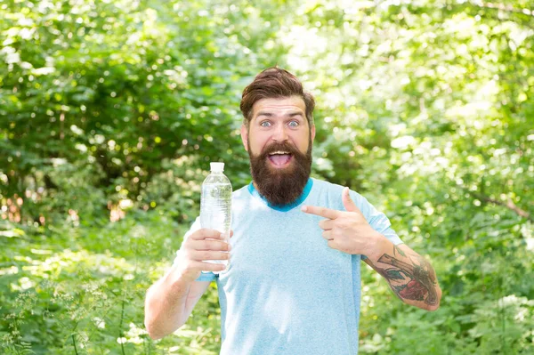 Glad man med skägg på sommaren föreslå peka finger på vattenflaska i skogen, törstig dag. — Stockfoto
