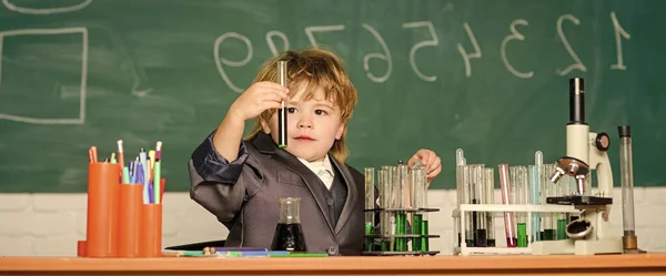 Unge i labbrock inlärningskemi liten unge lärande kemi i skolan lab. En liten pojke i kemiskåpet. Kemilabbet. Tillbaka till skolan. experimenterar med kemikalier. Förbättra den moderna medicinen — Stockfoto