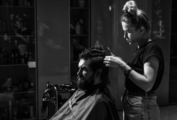 Close-up of barber styling beard to man in barbershop, Personal stylist barber