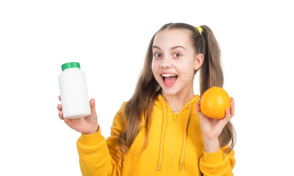 Feliz adolescente chica elegir entre naranja fruta y vitamina píldora aislado en blanco, suplemento mineral. — Foto de Stock