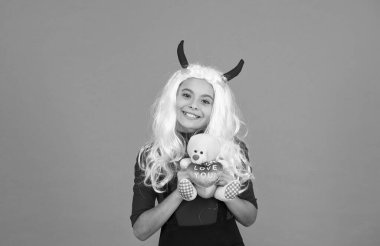 Oyuncak ayıyla mutlu cadı çocuk Cadılar Bayramı partisinde şeytan kostümleri giyer, cadılar bayramı hediyesi