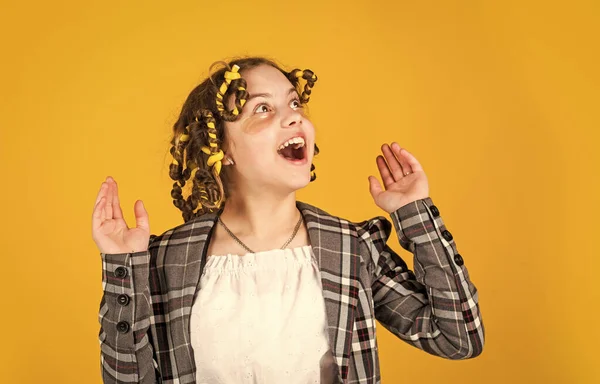 Beleza perfeita. Menina com encrespadores e grampos de cabelo em seu cabelo no fundo amarelo. Raparigas enroladas à volta do cabelo. Penteado lindo. Criar penteado bonito. Criança feliz. Salão de cabeleireiro — Fotografia de Stock