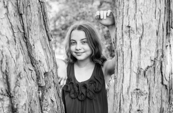 Κοριτσάκι μακριά σγουρά μαλλιά ακουμπά στον κορμό του δέντρου, κατασκήνωση — Φωτογραφία Αρχείου