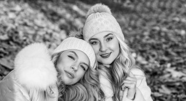 Uzun kıvırcık sarı saçlı güzel kadınlar ormanda yaprakları dökülen sonbahar şapkaları ve kalın giysiler giyerler.