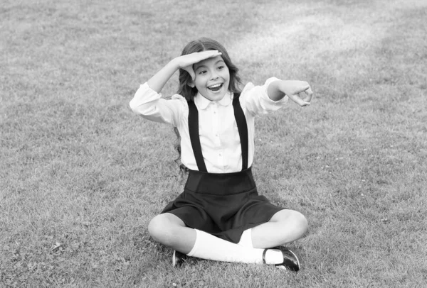 Joyeux enfant à l'école uniforme regarder devant doigt vert herbe paysage naturel à l'extérieur, avenir — Photo